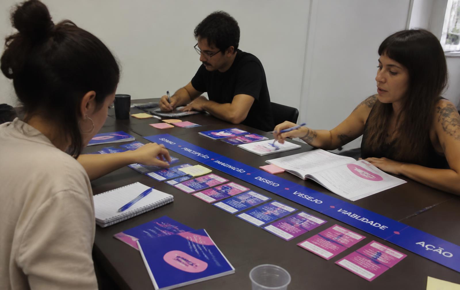 Mesa de trabalho durante uma sess\u00e3o de facilita\u00e7\u00e3o, com as cartas do m\u00e9todo espalhadas