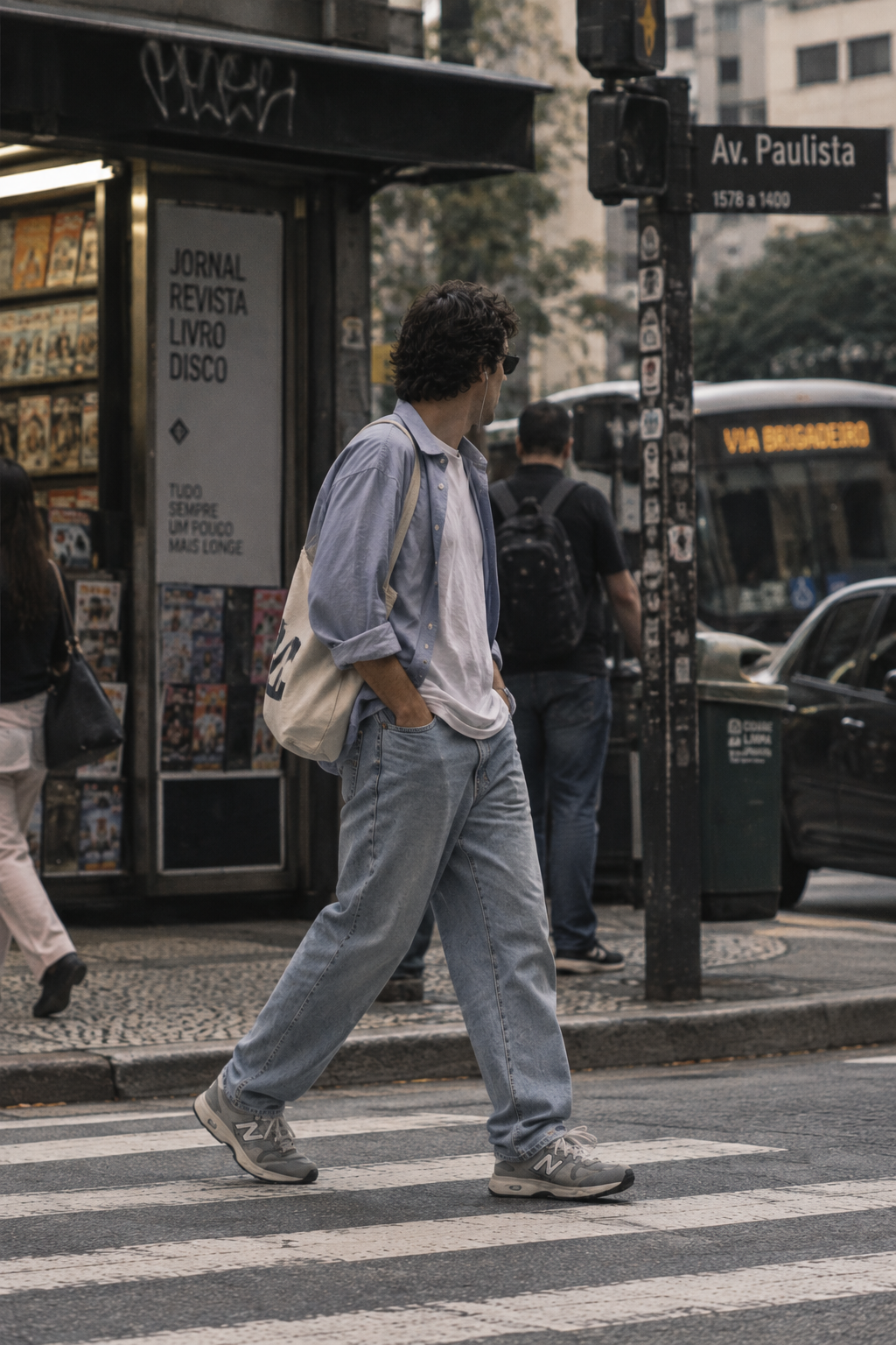 Jovem de jeans e New Balance atravessando uma rua de São Paulo em 2026